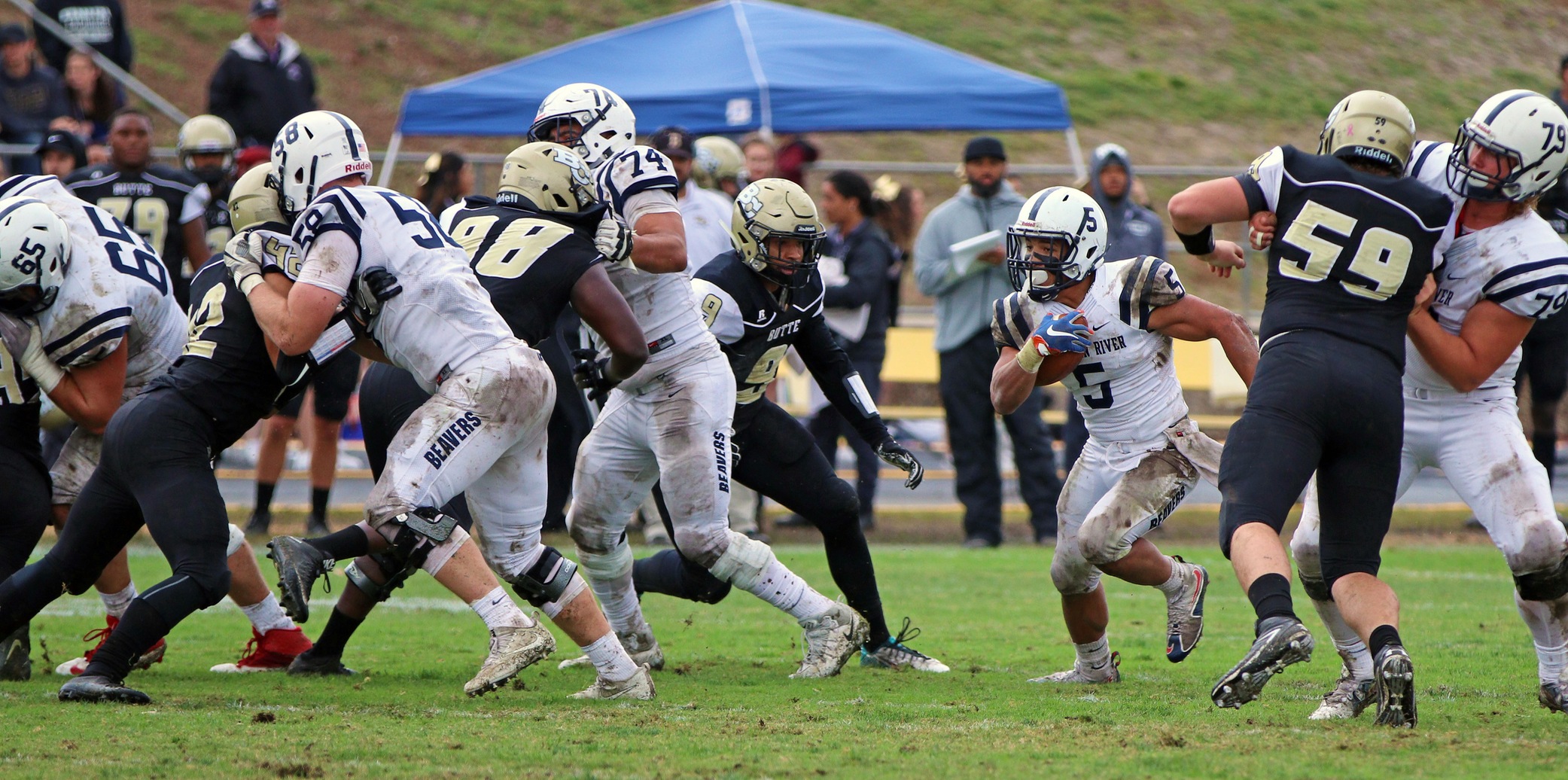 Diego Cervantes tackling a player while Evyn Holtz runs with the ball.